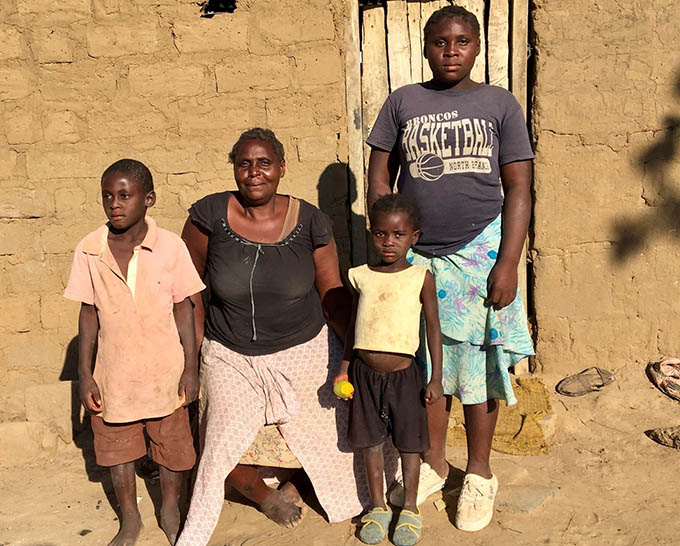 Estelle in front of her house with her children