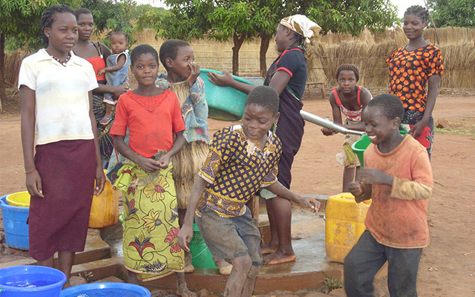 Children gather around a water pump in Niassa province, Mozambique. The Irish Aid programme has tackled malnutrition in Niassa through support to agricultural research; water, sanitation and hygiene (WASH); and community health structures.