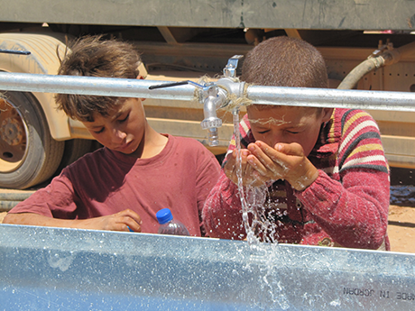 Syrian children enjoying clean water after the ICRC installed washing basins at several posts along the Syrian border in north-east Jordan. 05/07/2013 Photo credit: ICRC/ Alexandre Wagnieres