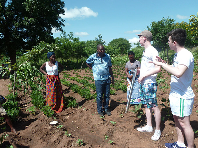 Diarmuid Curtin (right) and Jack O'Connor (left) field test their device on a field with local farmers, Kwitanda village, Balaka district, Malawi. Credit: Gorta Self Help Africa